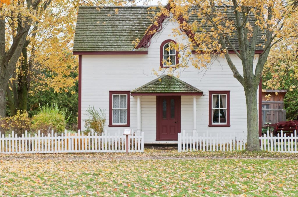 낙엽이 떨어지고 있는 마당있는 흰색 집