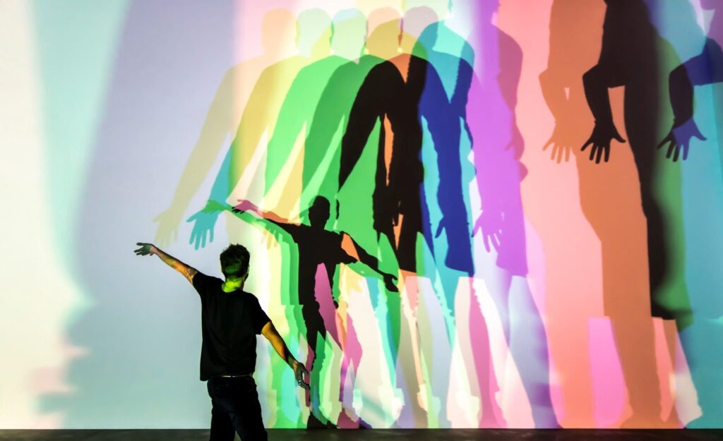 관람객이 불이 켜진 램프 앞을 지나가면 다양한 색의 그림자가 연출되어 작품이 완성되는 올라퍼 엘리아슨의 인터렉티브 아트, “Your uncertain shadow (colour)”, 2010